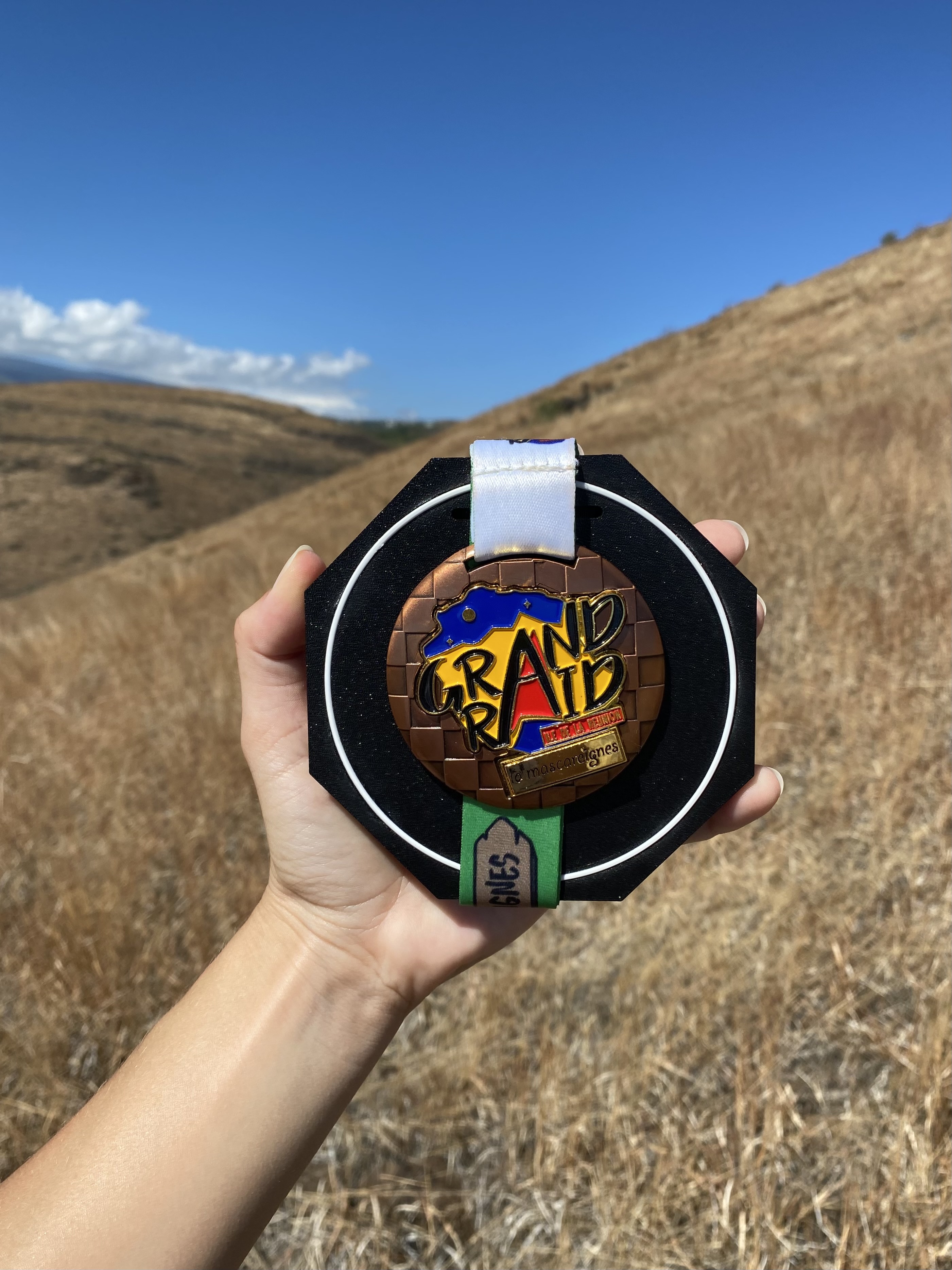 Module SUMO avec la médaille Grand Raid, tenu face aux collines